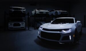 白いスポーツカーと高級車が並ぶ高級車専門ガレージの風景